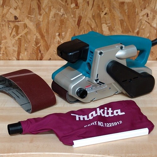 All the parts of the sander: dust bag, sander and sanding belt