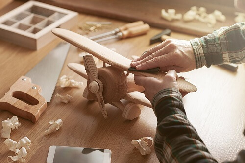 Using the sandpaper on a wood airplane